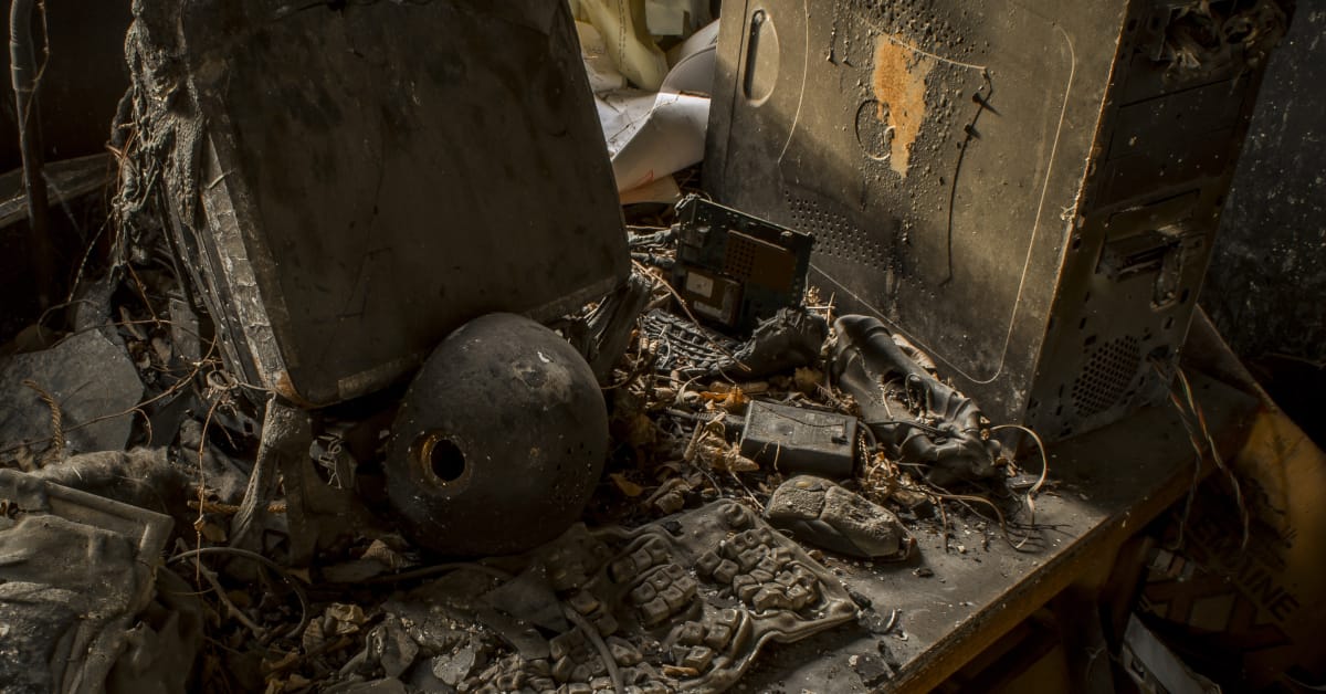 Burned desktop computere on a deak after a fire.